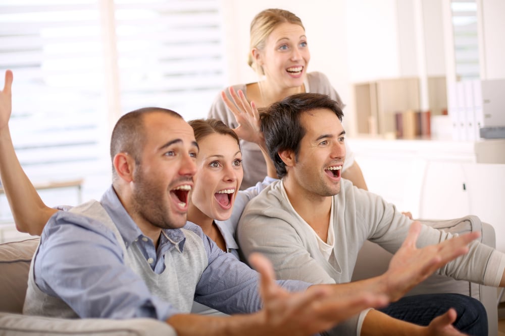 Cheerful group of friends watching football game on tv Cheerful group of friends watching football game on tv